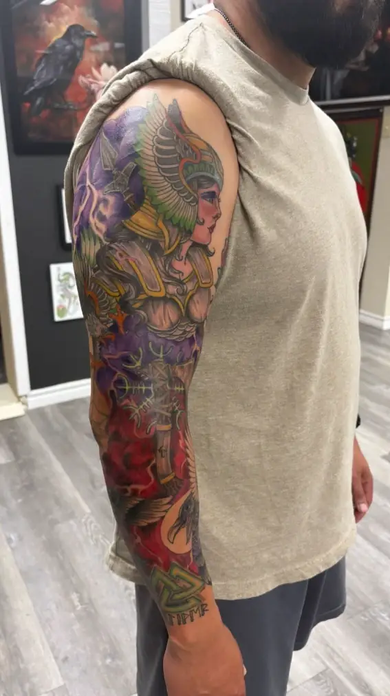 Color full sleeve tattoo with winged Valkyrie warrior, Norse runes, ravens and Valknut